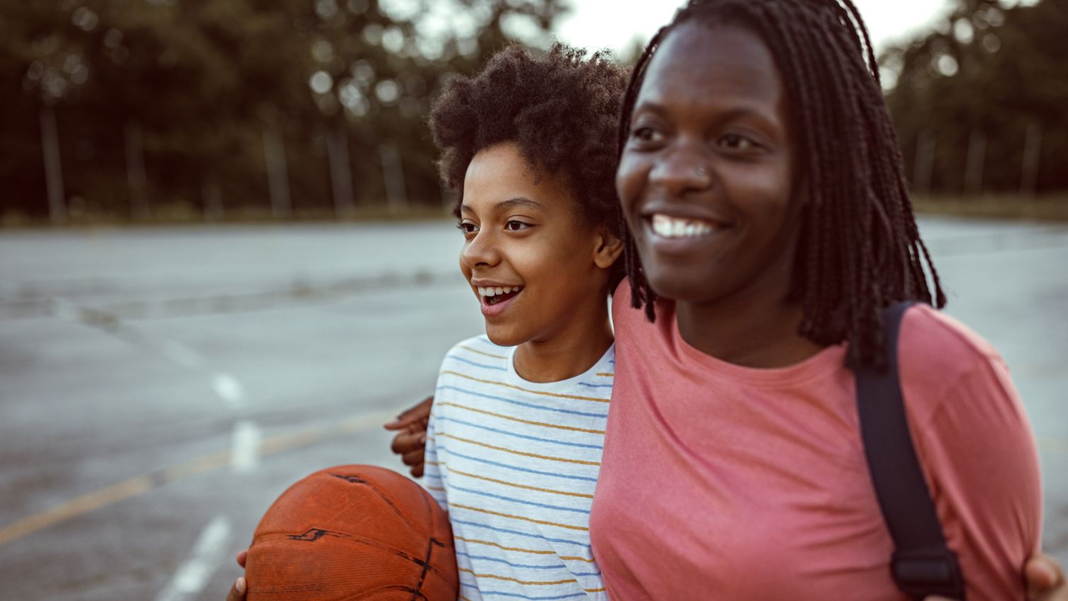 Two girls play basketball